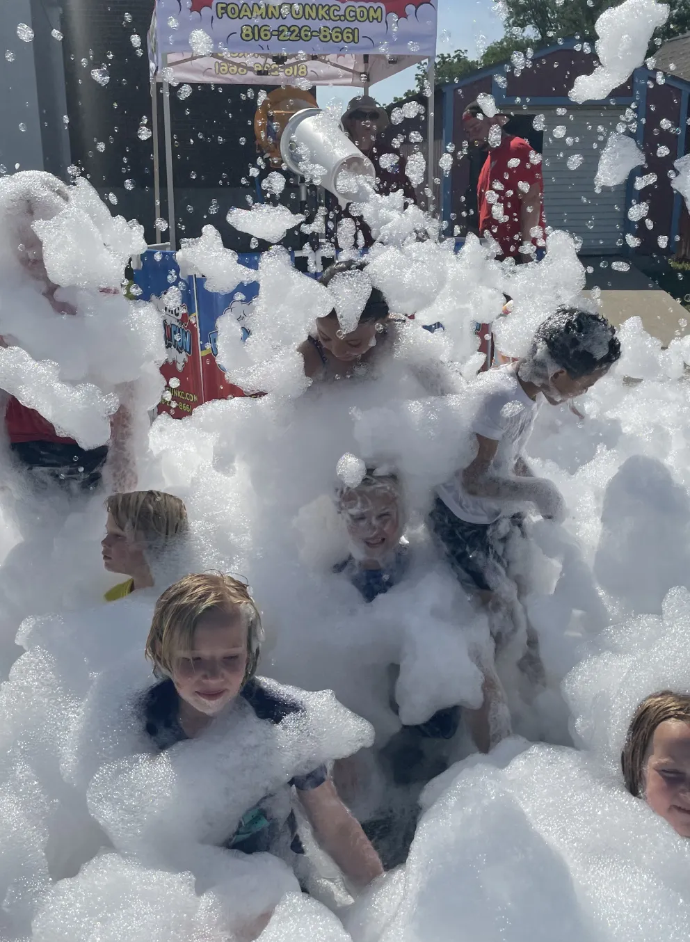 Photo of campers playing in white foam bubbles at foam party