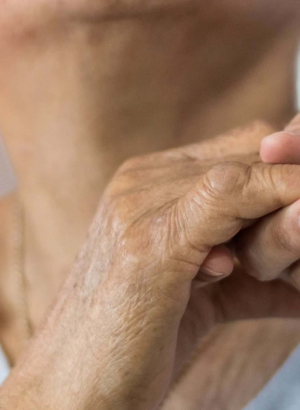 Elder person holding hand to a caregiver