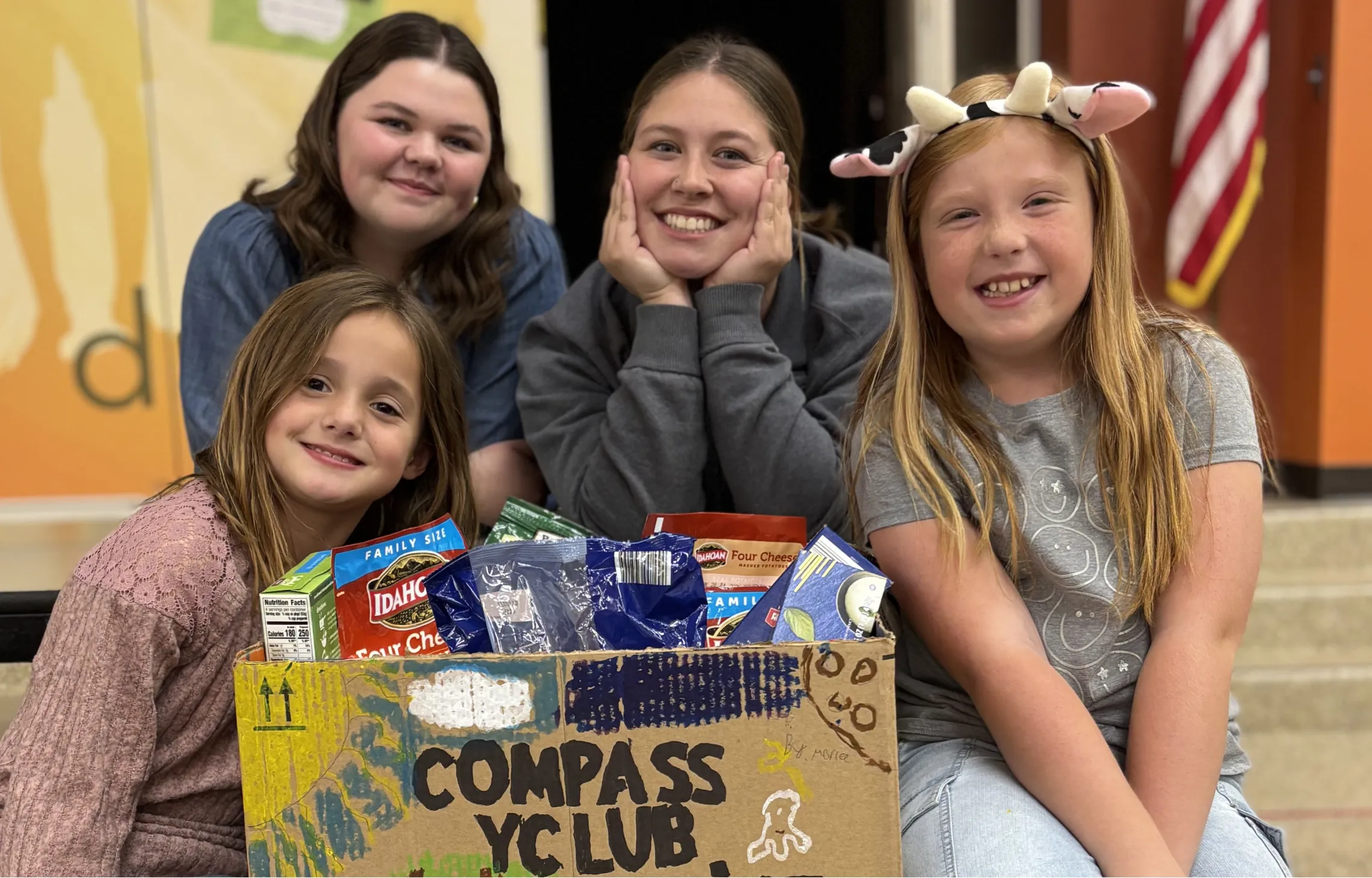 Group of students from Compass Y Club poses with box of food collected for YMCA of Greater Kansas City food pantries.