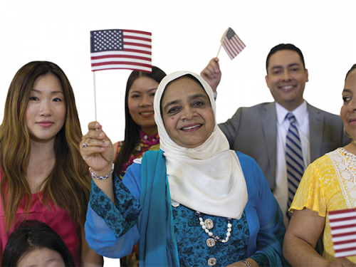 group of people each holding small American flags at naturalization ceremony