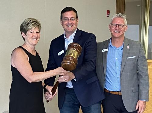 Outgoing Chief Volunteer Officer John Passanisi, center, passes the gavel to Dr. Michelle Robin, incoming Chief Volunteer Officer. Mark Hulet, Interim CEO, is on the right.