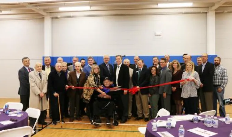 A group of donors and Y leaders pose before the ribbon cutting inside the new community center.