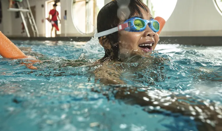 Child smiling while swimming at the Greater Kansas City Y.