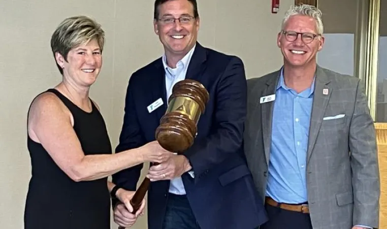 Outgoing Chief Volunteer Officer John Passanisi, center, passes the gavel to Dr. Michelle Robin, incoming Chief Volunteer Officer. Mark Hulet, Interim CEO, is on the right.