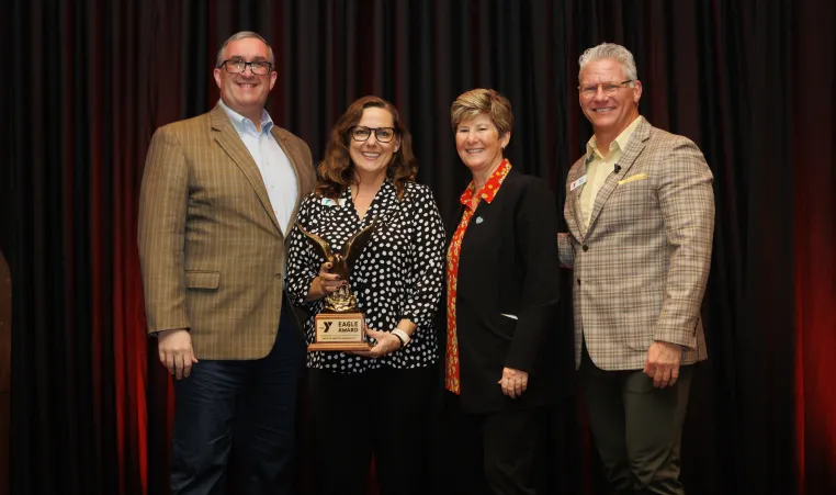 Representatives from the Cleaver Family YMCA accept the Eagle Award. Pictured from left to right: Aaron Lukken, Tami Carolan, Dr. Robin and Mark Hulet.