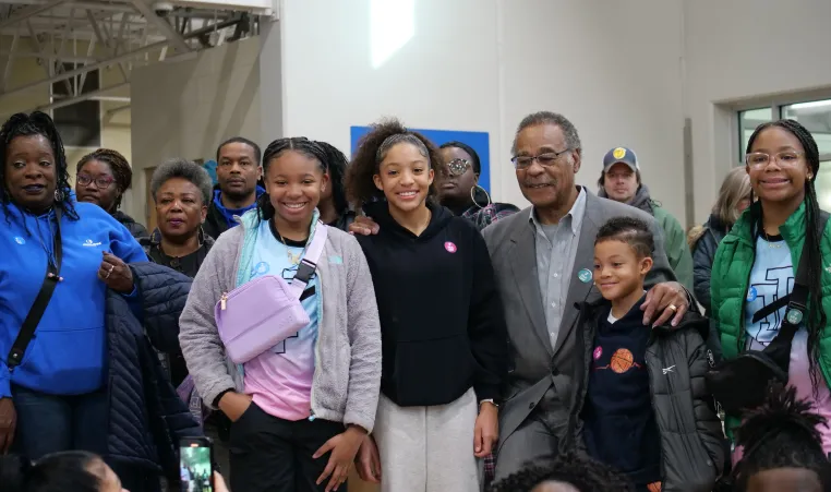 A group of volunteers of all ages at the MLK Day of Service event stand and smiles with Congressman Emanuel Cleaver.