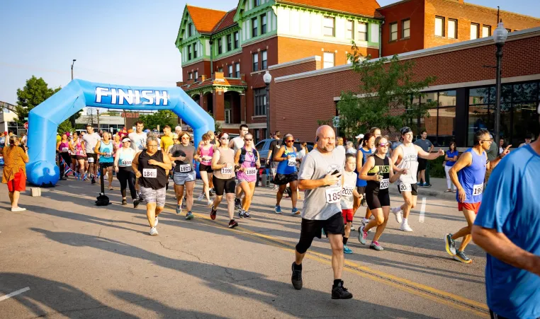 Runners cross the finish line of the Amelia Earhart Run in front of the Atchison Family YMCA/Cray Community Center