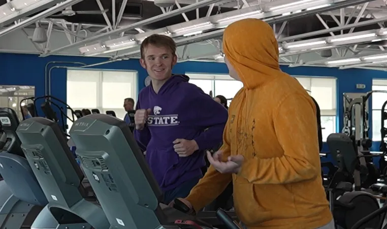 An adult mentor and youth match with Big Brothers Big Sisters enjoy time together exercising on treadmills at a greater Kansas City location as part of the Y's partnership