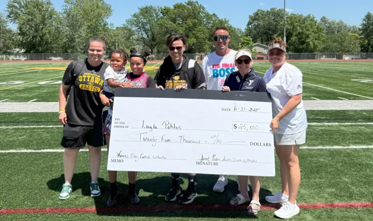 Photo of Ottawa MVP Layla Pohtos with representatives from Ottawa University and the YMCA of Greater Kansas City, holding an oversized check for her scholarship of $25,000