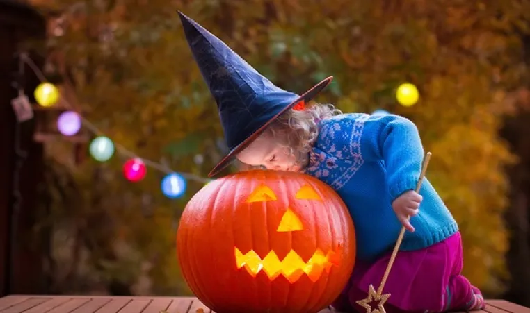Young girl looks inside jackolantern