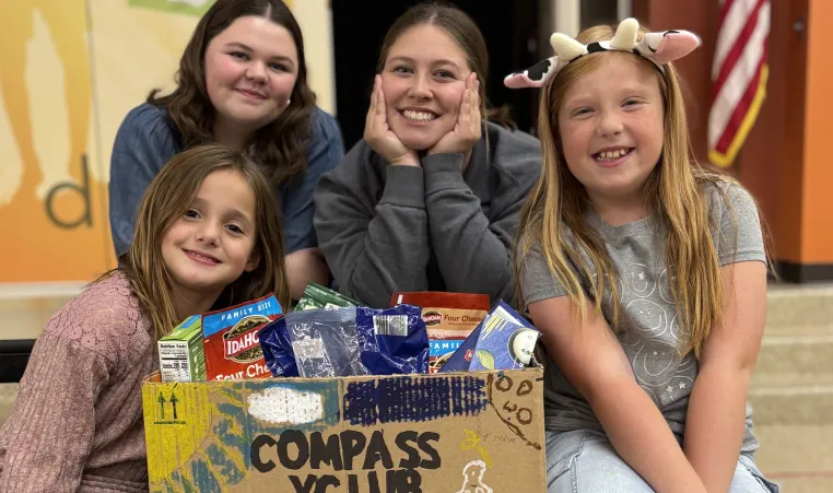 Group of students from Compass Y Club poses with box of food collected for YMCA of Greater Kansas City food pantries.