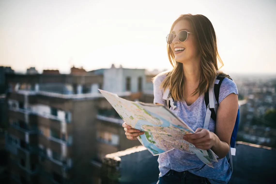 Photo of a woman with a map, and smiling